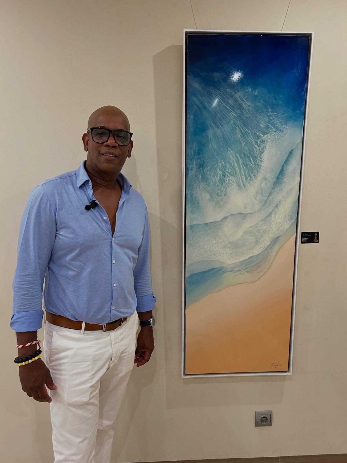 Raúl next to a tall seascape in resin